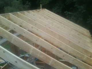 New roof rafters set over an addition before sheathing in Martin